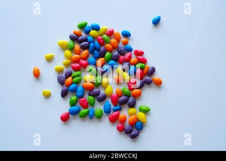 Mehrfarbige Dragees auf einer weißen, glänzenden Oberfläche. Stockfoto