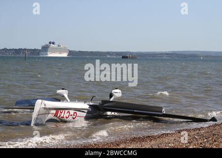 Das Kreuzfahrtschiff Britannia segelt an den Trümmern leichter Flugzeuge vorbei, die am Strand aufgewaschen wurden, nachdem es in der Nähe von Calshot Spit ins Meer gestürzt war. Zwei Menschen wurden aus dem Flugzeug gerettet. Stockfoto