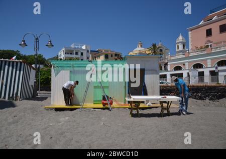 ISCHIA - KAMPANIEN- ITALIEN 20-05- 29. Ischia Brücke, Arbeiter tragen die Schutzmaske und halten die Sicherheit Abstand, bereiten Sie den Badestrand vor der offiziellen Eröffnung. Stockfoto