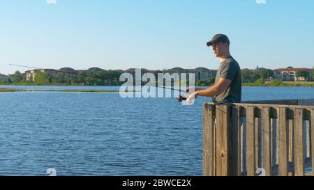 Fischer werfen Angelrute in See oder Fluss Wasser. Stockfoto