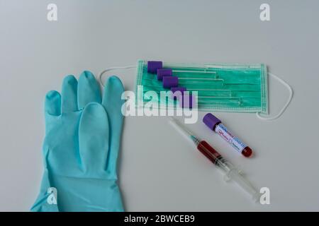 Blutproben auf das Vorhandensein von Coronavirus (COVID-19). Spritze und Röhrchen mit einer Blutprobe, die positiv auf COVID-19 getestet wurde. Stockfoto