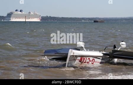 Die Trümmer leichter Flugzeuge wuschen am Strand, nachdem sie in das Meer nahe Calshot Spit stürzten. Zwei Menschen wurden aus dem Flugzeug gerettet. Stockfoto