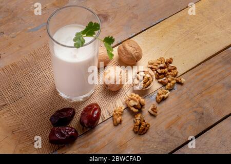 Vegane Milch aus Walnüssen im Glas auf Holztisch, gesundes Frühstück Stockfoto