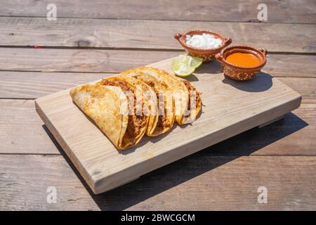 Tacos von Birria mit Sauce, Zwiebel und Zitrone Stockfoto