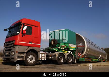 Ansicht eines roten LKW, Tieflader-Sattelauflieger und übergroße Last. Langes Fahrzeug. Stockfoto