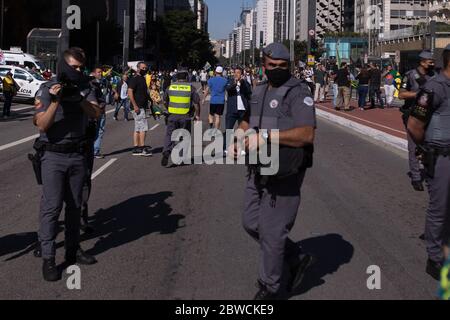 Sao Paulo, Brasilien. Mai 2020. Polizeibeamte stehen bei regierungskritischen Protesten auf der Avenida Paulista. Die Zahl der Todesfälle in Corona in Brasilien steigt weiterhin rasant an. Brasiliens rechtspopulistischer Präsident Bolsonaro sieht die Lungenerkrankung als "Mil-Grippe" und lehnt Schutzmaßnahmen ab. Bisher haben sich 498,440 Menschen im größten Staat Südamerikas als infiziert erwiesen. Quelle: Andre Lucas/dpa/Alamy Live News Stockfoto