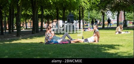 Glasgow, Schottland, Großbritannien. Mai 2020. Menschen, die auf dem Gras in Glasgow Green an einem warmen und sonnigen Sonntagnachmittag liegen. Die schottische Regierung kündigte am 28. Mai eine Lockerung der Sperrregeln für das Coronavirus an. Kredit: Skully/Alamy Live News Stockfoto