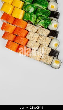 Sushi-Set Nigiri und Sushi-Brötchen.verschiedene Sushi und Brötchen mit Fischkäse und Chuka-Salat in Essstäbchen auf weißem Hintergrund isoliert. Japanische Küche. Stockfoto
