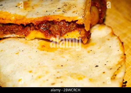 Quesadilla mit Hackfleisch, Wurst, roten Bohnen, Mais, Zwiebeln und Tomatensauce. Ein traditionelles mexikanisches Essen. Nahaufnahme Stockfoto