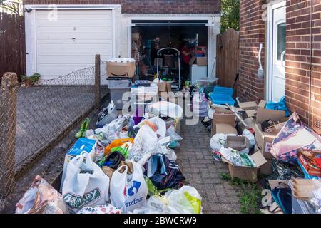 Müllbeseitung aus einer Wohngarage. Sortieren in Stapel zu halten und wegwerfen. Stockfoto