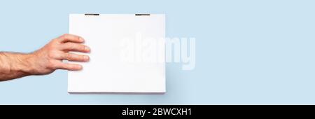 Sichere Lieferung. Vorderansicht des Lieferkastens in einer männlichen Hand. Stockfoto