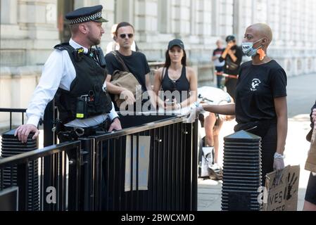 London, Großbritannien. Mai 2020. Ein Polizist (L) spricht mit einem Protestierenden während eines Protestes über den Tod von George Floyd außerhalb Downing Street in London, Großbritannien, am 31. Mai 2020. Trotz des Verbots von Massenversammlungen in Großbritannien versammelten sich Tausende von Menschen Sonntag in London und Manchester, um über den Tod von George Floyd zu protestieren, einem unbewaffneten schwarzen Mann, der am Montag von einem weißen Polizisten im mittleren Westen des US-Bundesstaates Minnesota erstickt wurde. Kredit: Xinhua/Alamy Live News Stockfoto