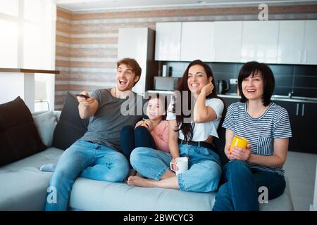 Eine große Familie schaut fern. Brüder, Schwestern, Mutter, Großmutter und Enkelkind Stockfoto