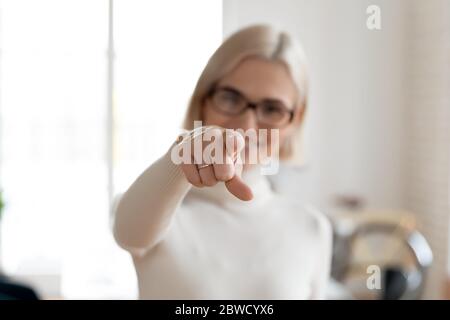 Lächelnde Frau, die mit dem Finger auf die Kamera zeigt. Stockfoto