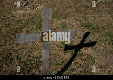 Ein Holzkreuz, das am 30. Mai 2020 in South London im Vereinigten Königreich einen Schatten auf dem West Norwood Cemetery wirft. Foto von Sam Mellish Stockfoto