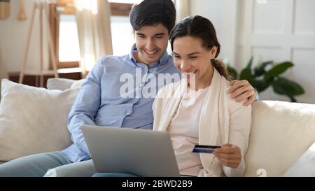 Happy paar Online-Shopping auf Laptop mit bankcard Stockfoto
