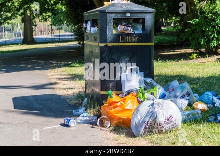 Überfließender Abfalleimer im Londoner Park Stockfoto