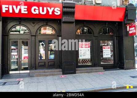 Fünf Jungs Fast-Food-Restaurant Betrieb nehmen nur mit strengen sozialen Distanzierungsregeln Stockfoto