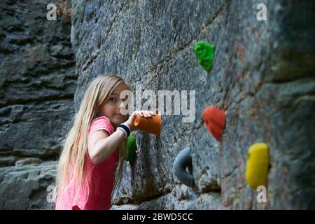 Mädchen mit Spaß beim Klettern Training auf Boulder Wand Stockfoto