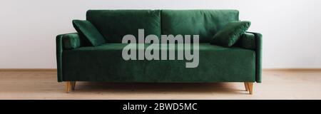 Modernes grünes Sofa mit Kissen im Zimmer, Panoramabild Stockfoto