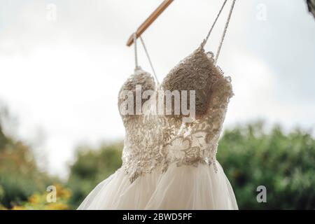 Nahaufnahme von geschnürten Brust Teil des Brautkleides gegen Himmel und grüne Vegetation Hintergrund. Konzept für Hochzeitstag. Stockfoto