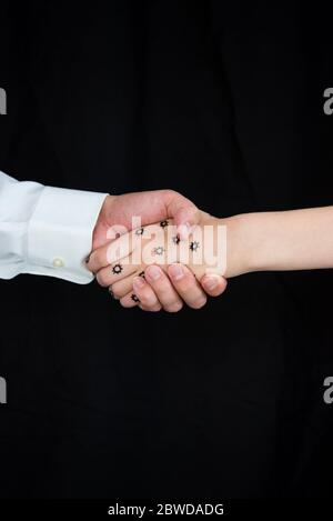 Konzeptfoto einer Person mit COVID-19, die einen Handschlag gibt. Schwarzer Hintergrund mit Kopierbereich. Stockfoto