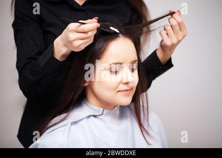 Professionelle Stylistin macht eine junge Frau eine schöne Frisur Stockfoto