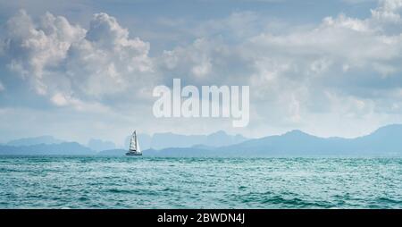Einbänmigisches Segelboot in der Andamanensee in Thailand mit der Krabi-Küste am Horizont Stockfoto