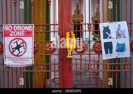 Am Eingang zum berühmten Tempel Wat Po in Bangkok, Thailand, informieren Schilder die Besucher über die Kleiderordnung und verbieten die Verwendung von Drohnen Stockfoto