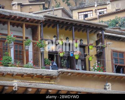 Ein Blick auf ein Holzhaus in der historischen Stadt Masouleh, Blumen auf der Veranda des Hauses, im Iran, in Gilan angeordnet Stockfoto