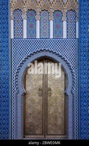 Nahaufnahme der goldenen Tür und der verzierten Fliesenarbeiten des Königspalastes in Fez, Marokko Stockfoto