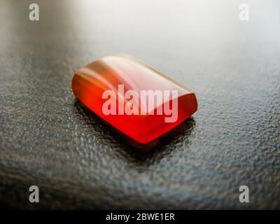 Jemenitische rot aqeeq Achat Stein. Jemenitische opal roten Stein. Jemenitische Achat roten Stein. closeup der natürlichen Jemen aqeeq auf dunklen Tisch. Muslime verwenden Achat Stein als Stockfoto