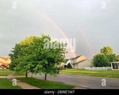 Paar rainbowl über city Michigan. Regenbogen über der Stadt Ann Arbor, USA. Regenbogen über dem blauen Himmel im Frühjahr, Wohngebiet. Nahaufnahme. Backgr Stockfoto