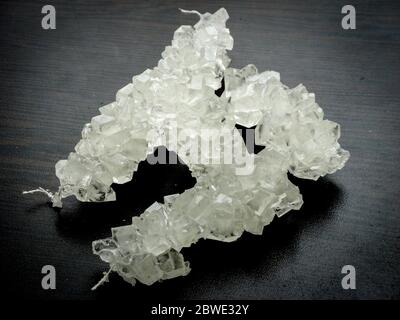 Nabat weiß mit schwarzem Hintergrund, iranischen Rock Candy auf einen hölzernen Tisch. Es ist von der Kristallisation von Zucker. Nabat ist ein Iranischer Dessert verzehrt Stockfoto