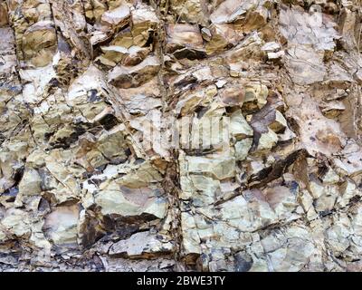 Oberfläche der Felswand. Die Wand des Berges. Felshintergrund. Schichtung von Felsen. Stein Hintergrund von brauner Farbe. Stockfoto