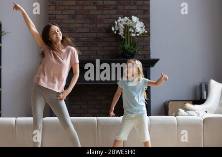 Überglücklich junge Mutter haben Spaß tanzen mit Tochter Stockfoto