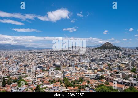 Luftbild des Lycabettus und der Stadt Athen, Blick vom Akropolis-Hügel in Griechenland. Blauer Himmel mit Wolken, sonniger Frühlingstag. Stockfoto