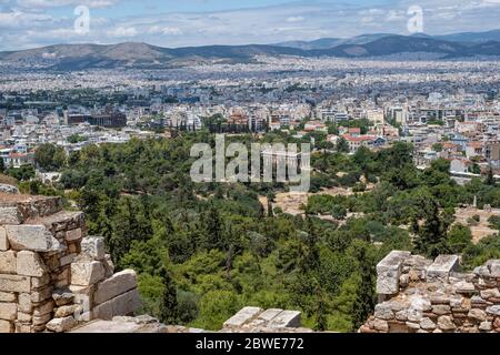 Athens Stadtbild und Hephaestus Tempel gegen blauen bewölkten Himmel in einem Frühlingstag. Blick vom Akropolis-Hügel. Attica, Griechenland Stockfoto