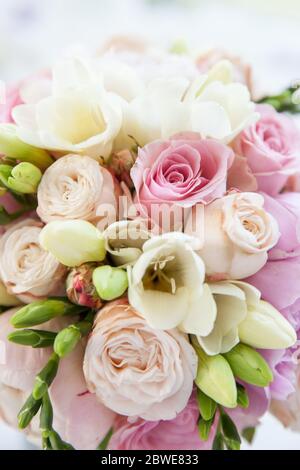 Nahaufnahme eines Blumenstraußes, bestehend aus Geranien, Nelken, Rosen in hellen Hochzeitsfarben Stockfoto