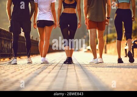 Eine Gruppe junger Menschen verläuft entlang der Straße in den Park. Stockfoto