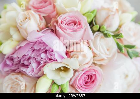 Nahaufnahme eines Blumenstraußes, bestehend aus Geranien, Nelken, Rosen in hellen Hochzeitsfarben Stockfoto