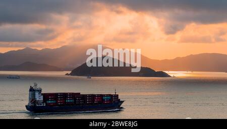 Container-Schiffe transportieren Fracht in Hong Kong vom Festland China, Victoria Harbour, Hong Kong, China. Stockfoto