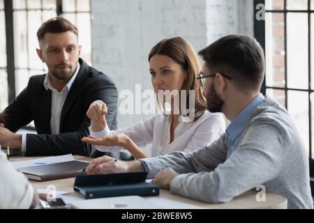 Ernsthafte selbstbewusste Geschäftsfrau spricht, Projekt bei Unternehmensmeeting diskutieren Stockfoto