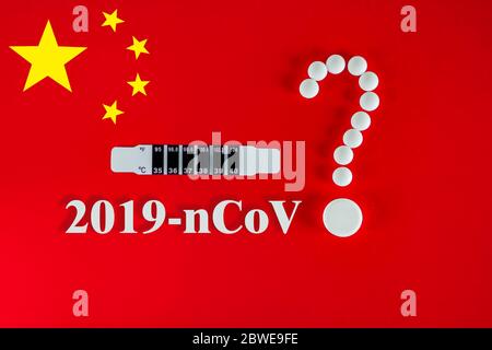 Weiße Pillen in Form eines Fragezeichens auf rotem Hintergrund der chinesischen Flagge mit Inschrift 2019-nCoV und Textraum. 2019 Roman Coro Stockfoto