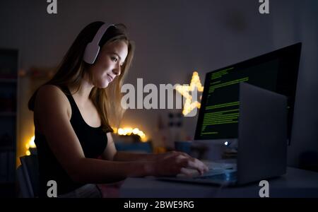 Junges Mädchen mit Computer im Haus sitzen, Online-Chat-Konzept. Stockfoto