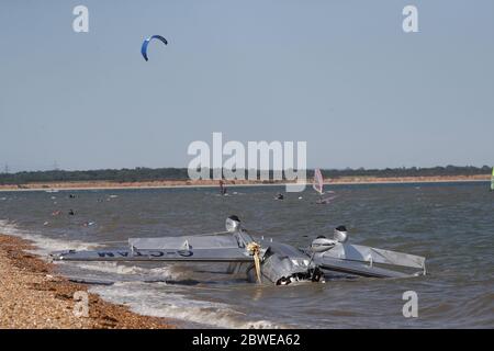 Die Trümmer leichter Flugzeuge wuschen am Strand, nachdem sie in das Meer nahe Calshot Spit stürzten. Zwei Menschen wurden aus dem Flugzeug gerettet. Stockfoto