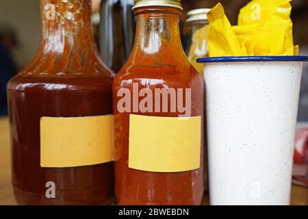 Schließen Sie Flaschen Dip Sauce und Servietten Stockfoto