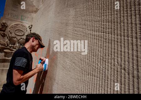 Christopher Saxon, ein Afghanistan-Veteran, der an PTSD leidet, versucht, Graffiti vom Kriegsdenkmal nach den Unruhen als Reaktion auf die Tötung von George Floyd und Sean Reed in Indianapolis zu entfernen.Saxon sagte, er diente bei Golf Company, 1st Platoon, des 2. Bataillons, 5th Marines, in Afghanistan im Jahr 2012, Und ist für PTSD zu 100 % deaktiviert. Saxon sagte, er habe Angst, nur zum Denkmal zu gehen, aber sagte: "Ich habe für die Rechte der Menschen und die Redefreiheit gekämpft. Saxon nannte die Polizei, die George Lloyd tötete, "Müllleute", sagte aber, nicht alle Polizisten seien schlecht. Er sagte, er spürte das Graffiti an Stockfoto