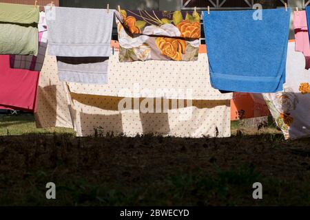 Eine Wäscheleine mit bunten Laken, Handtüchern in der Nachmittagssonne und frischer Luft gefüllt. Im Dorf Nida an der Kurischen Nehrung in Litauen. Stockfoto
