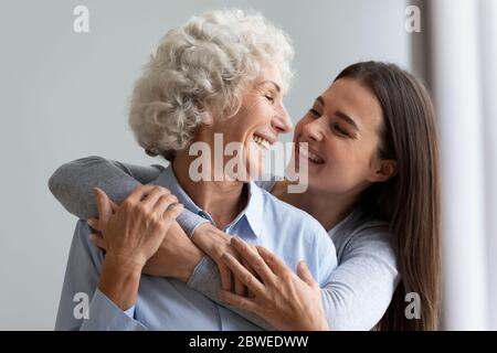 Liebevolle fröhlich Erwachsene Tochter umarmt ältere Mutter lachen Spaß Stockfoto